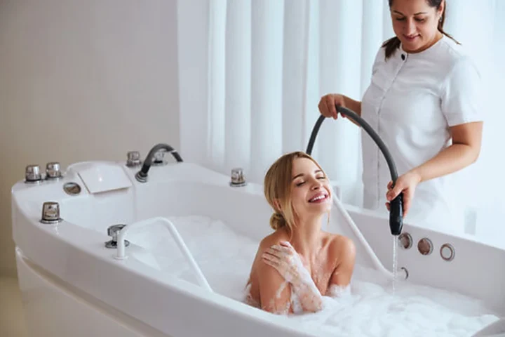 Terapeutka prowadzi hydromasaż strumieniem wody nad wanną